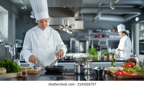 Restaurant Kitchen: Black Female Chef Cooking Delicious And Traditional Authentic Food, Uses Oil On Pan Getting Ready To Fry Organic Free Range Meat Patty. Preparing Gourmet Dishes. Wide Shot