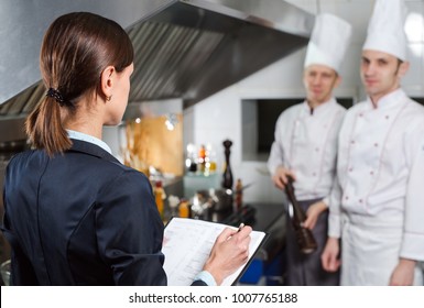 Restaurant manager briefing to his kitchen staff in the commercial kitchen - Powered by Shutterstock