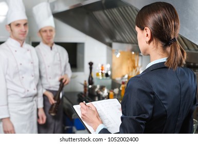 Restaurant manager briefing to his kitchen staff in the commercial kitchen - Powered by Shutterstock