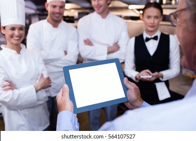 Restaurant manager briefing to his kitchen staff in the commercial kitchen - Powered by Shutterstock