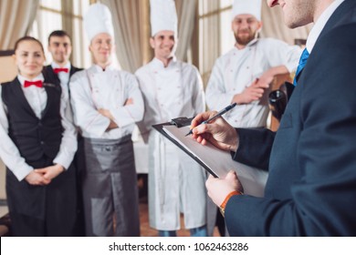 restaurant manager and his staff in kitchen. interacting to head chef in commercial kitchen. - Powered by Shutterstock