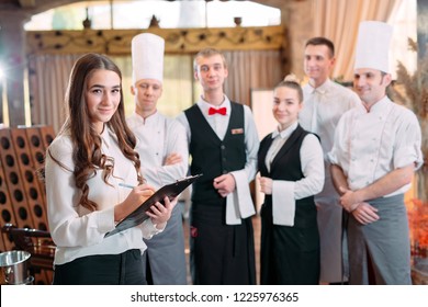 restaurant manager and his staff in kitchen. interacting to head chef in commercial kitchen - Shutterstock ID 1225976365