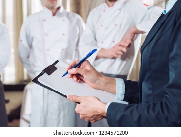 restaurant manager and his staff in kitchen. interacting to head chef in commercial kitchen. - Powered by Shutterstock