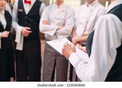 restaurant manager and his staff in kitchen. interacting to head chef in commercial kitchen - Powered by Shutterstock