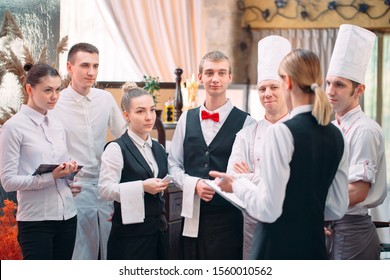 Restaurant Manager And His Staff In Kitchen. Interacting To Head Chef In Commercial Kitchen