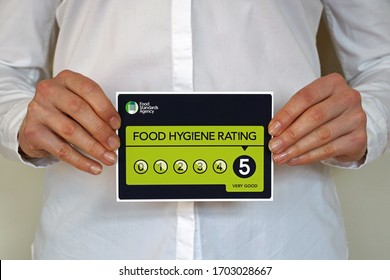 Restaurant Manager Holds A Sticker With Food Hygiene Rating 5 From The United Kingdom Food Standards Agency