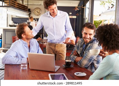 Restaurant manager talking to customers at their table