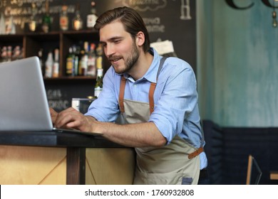 Restaurant Manager Working On Laptop, Counting Profit.