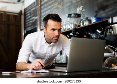 Restaurant Manager Working On Laptop, Counting Profit