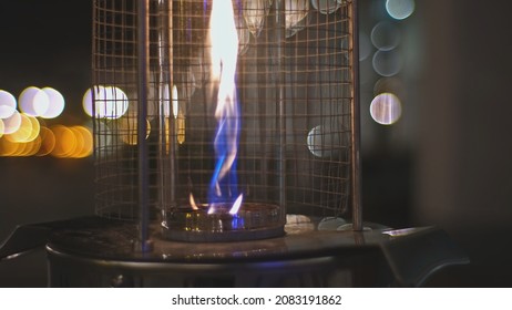 Restaurant Outdoor Patio Garden Gas Heater With Blue And Yellow Flame Burning On Cold Autumn Evening