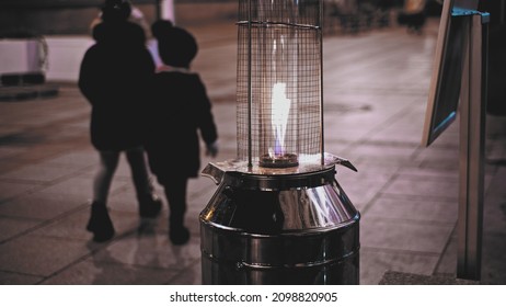 Restaurant Outdoor Patio Garden Gas Heater With Blue And Yellow Flame Burning On Cold Evening