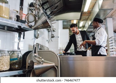 Restaurant owner with chef in kitchen. Cook talking with manager at cafe. - Powered by Shutterstock