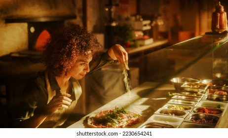 In Restaurant Professional Female Chef Preparing Pizza, Adding Ingredients, Special Sauce, Cheese, Traditional Family Recipe. Authentic Sunny Italian Pizzeria, Cooking Organic Food - Powered by Shutterstock