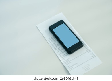 Restaurant queue pager placed on receipt on wooden table. Perfect for concepts of food service technology, customer waiting system, smart restaurant operations, and digital order notification tools.