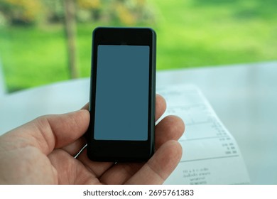 Restaurant queue pager placed on receipt on wooden table. Perfect for concepts of food service technology, customer waiting system, smart restaurant operations, and digital order notification tools.