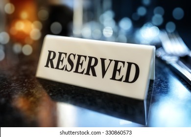 Restaurant reserved table sign with places setting and wine glasses ready for a party