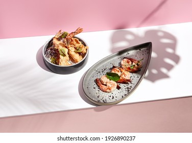 Restaurant Seafood - Shrimp Grill Seafood Plate. Appetizer Food Plate On White Table With Pink Wall. Day Sunlight With Hard Shadow Of Monstera Palm Leaves. Summer Or Spring Food Concept