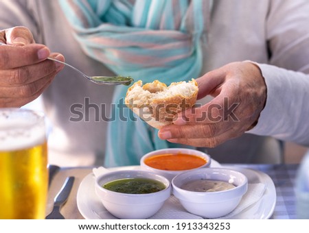 At the restaurant table a woman tastes one of the
typical sauces of the Canary Islands, called "mojo"