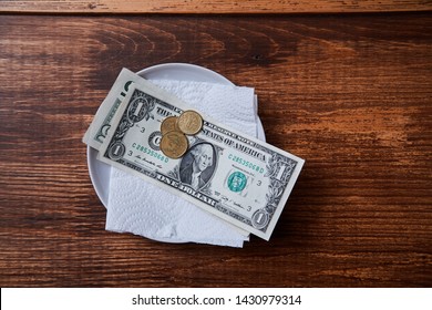 Restaurant Tips Or Gratuity. Banknotes And Coins On A Plate