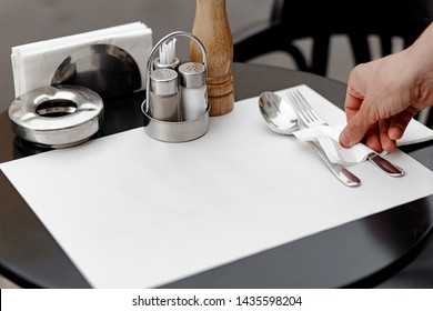 Restaurant waiter serves a table, close-up. The waiter serves empty tableware, table setting. The waitress puts the fork, sets the table - Powered by Shutterstock