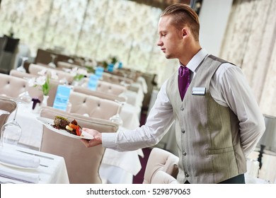 Restaurant Waiter Serving Table With Food