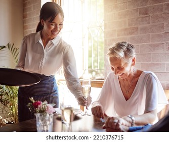 Restaurant, waitress and senior woman wine tasting for luxury, celebration or fine dining at a vineyard or in hospitality industry. Sommelier service with quality alcohol drink, champagne and glass - Powered by Shutterstock