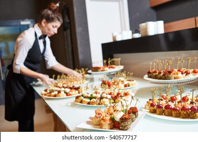Restaurant waitress serving table with food