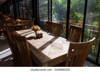 Restaurant Wooden Long Table With Artificial Grass And Flower In Morning With Outside Green Natural Environment.