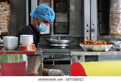 Restaurant Workers Wears A Mask On His Face While The Works At Of As A Precaution Against The Spread Of The COVID-19 Coronavirus,  In The Gaza Strip, On March 19, 2020. Photo By Abed Rahim Khatib