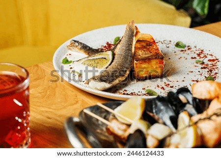 restaurant-style presentation of Seabass with potato gratin and celery sauce, elegantly served on a wooden table, yellow background. Perfect choice for culinary promotions and food enthusiasts