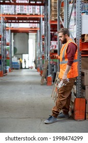 Restful Worker Of Warehouse Scrolling In Smartphone At Break