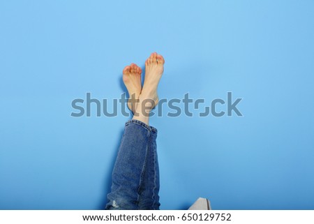 Resting female legs on holiday,foot on foot on blue background, wants at sea