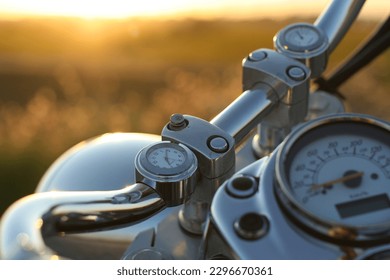 resting motorbike's handlebar . clock with speedometer and the sunset