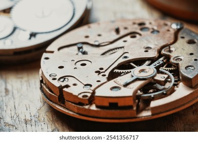 Resting on the workbench, these watch movements exhibit a complex design of gears and screws, highlighting the watchmaker’s dedication to precision and intricate mechanical design - Powered by Shutterstock