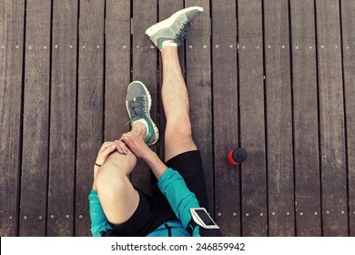 resting sportsman's legs sitting on the wooden floor with red sport plastic bottle, view from the top - Powered by Shutterstock