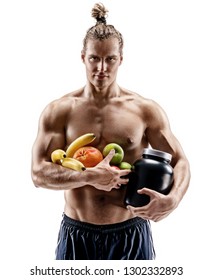 Resting Time. Handsome Muscular Man Holding Fresh Fruits And Big Jar Of Sports Nutrition Isolated On White Background. Organic Food And Health Concept