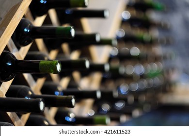 Resting wine bottles stacked on wooden racks in cellar 