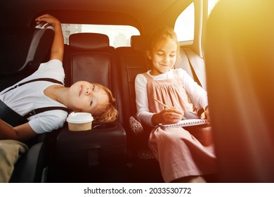 Restless siblings riding back seat in car  View from inside salon  Boy is bored  he's run out things to do  Girl is drawing 