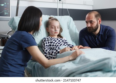 Restless Uneasy Careful Parents Conversating About Little Girl Illness Evolution While In Pediatric Hospital Patient Recovery Ward Room. Worried Nervous Young People Talking About Healthcare Treatment