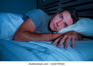 Restless Worried Young Attractive Man Awake At Night Lying On Bed Sleepless With Eyes Wide Opened Suffering Insomnia Sleeping Disorder Depressed And Sad In Rest Privation Stress Concept