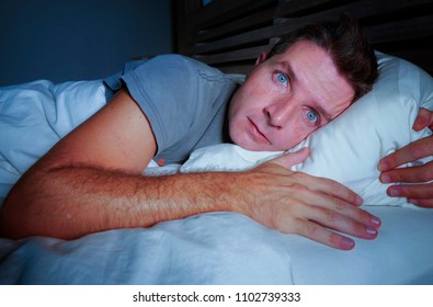 Restless Worried Young Attractive Man Awake At Night Lying On Bed Sleepless With Eyes Wide Opened Suffering Insomnia Sleeping Disorder Depressed And Sad In Rest Privation Stress Concept