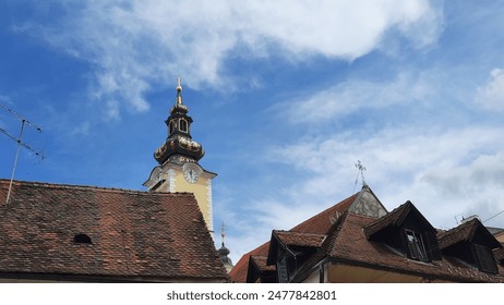 A restored clock tower with  golden dome, against a vibrant blue sky in Zagreb, Croatia. This historic architecture showcases the city's dedication to heritage preservation and cultural pride. - Powered by Shutterstock