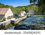 Restored mill houses and water race from the old hydro electric plant near Skradinski Buk waterfalls within Krka National Park, Croatia