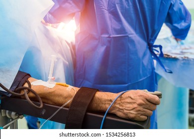 Restrainted patient on the operation table in surgery with a drip in a hand. Patient's hand with a sensor,Hand critically ill patients. IV fluids. Closeup. - Shutterstock ID 1534256813
