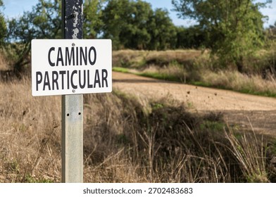Restricted Access Warning: Focus on the Sign and Shallow Depth of Field on the Road. 'Private Road'.