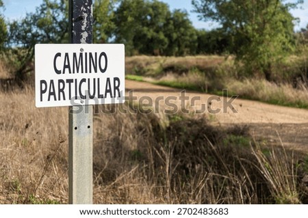 Restricted Access Warning: Focus on the Sign and Shallow Depth of Field on the Road. 'Private Road'.