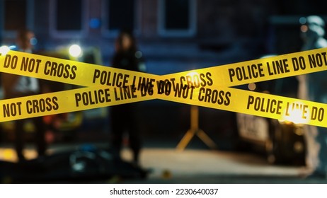 Restricted Area: Yellow Tape Showing Text "Police Line Do Not Cross". Blurred Background with Crime Scene Investigation Squad Working on a Murder Case at Night. Cinematic Aesthetic Shot - Shutterstock ID 2230640037