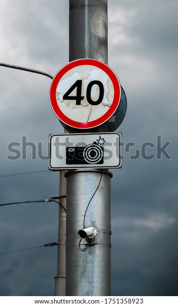 Restrictive road sign and information sign about\
the camera mounted on a street lighting pole. under the signs a\
surveillance camera