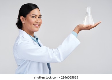 The Results Are In. Cropped Portrait Of An Attractive Young Female Scientist Holding A Beaker Filled With Liquid In Studio Against A Grey Background.