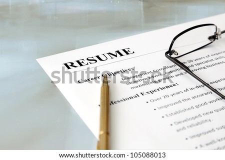 Resume on the Table. Closeup of resume with pen and glasses on the table